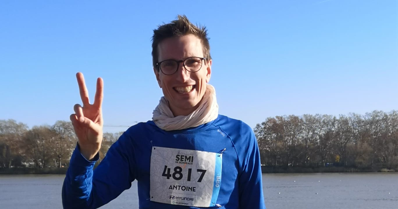 Antoine, dossard du semi-marathon de Bordeaux, fait le V de la victoire sur les quais